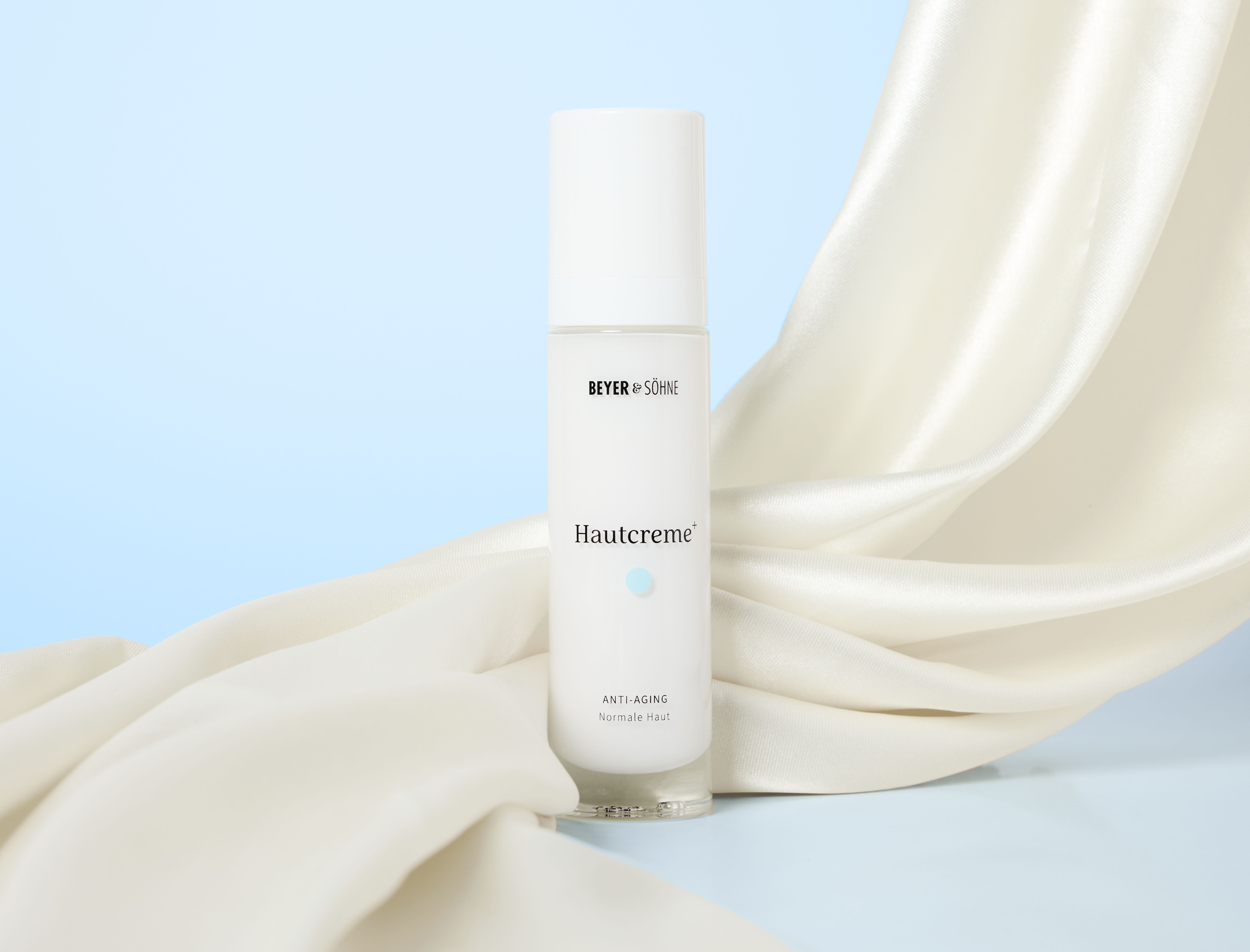 Hautcreme+ Anti-Aging Gesichtscreme von Beyer & Söhne für empfindliche Haut, im Airless-Spender auf weißer Seide, helle minimalistische Farbwelt